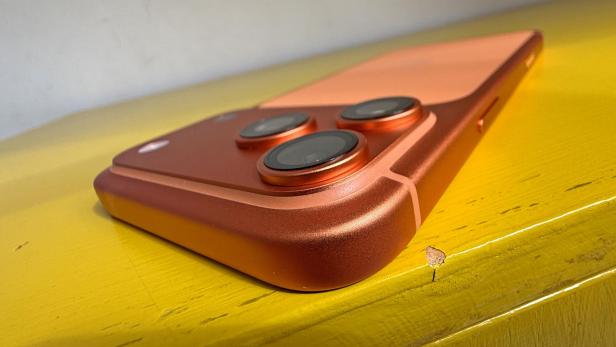 Ein rosafarbenes iPhone 17 Pro Max liegt auf einer gelben Oberfläche.