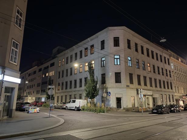 Ein Gebäude an einer Straßenkreuzung in Wien bei Nacht.