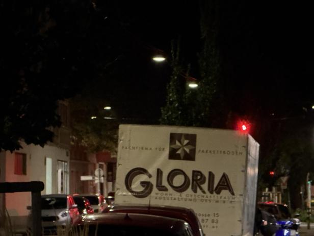 Ein Lieferwagen der Firma Gloria Parkettböden steht nachts auf der Straße.