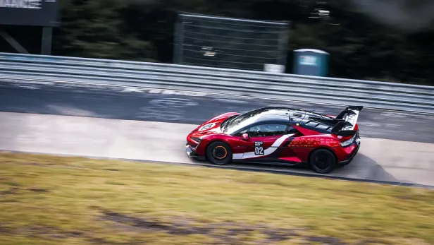 Ein rot-schwarzer Yangwang U9 Xtreme auf einer Rennstrecke.