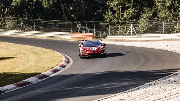 Ein roter Yangwang U9 Xtreme auf einer Rennstrecke.