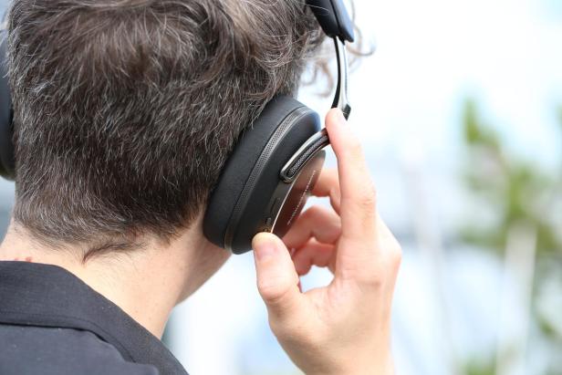 Ein Mann bedient die Bowers & Wilkins PX8 S2 Kopfhörer.
