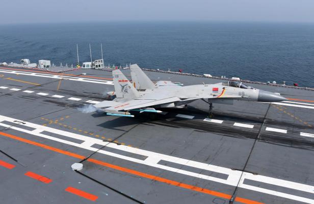 Ein J-15-Kampfflugzeug auf dem Flugdeck eines Flugzeugträgers.