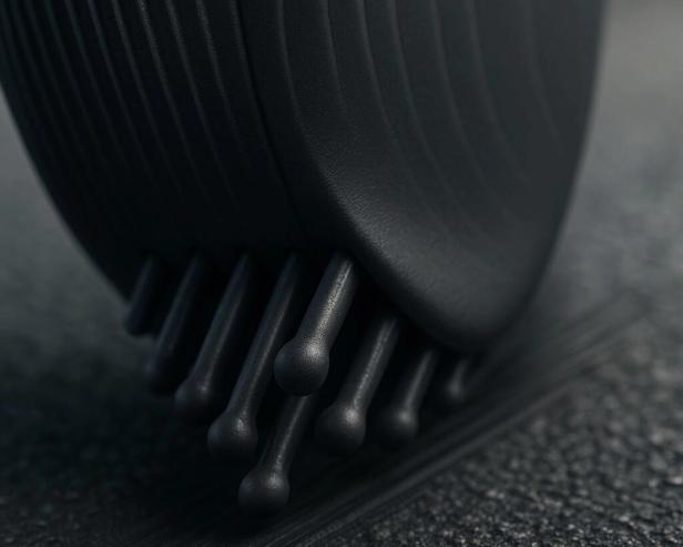 Nahaufnahme einer schwarzen Bürste mit abgerundeten Borsten auf einer dunklen Oberfläche.