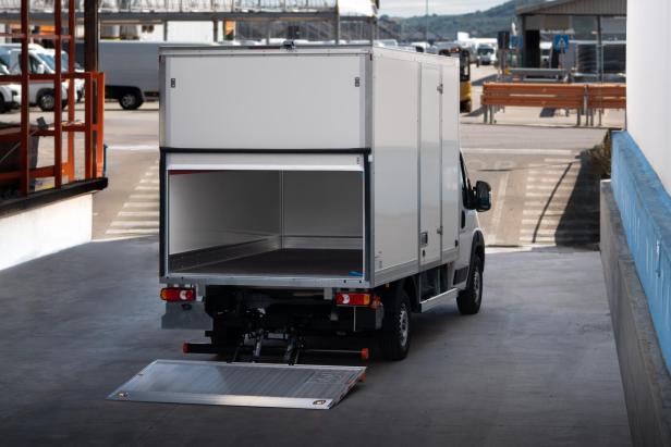 Ein weißer Lastwagen mit einer Rampe auf der Ladefläche.