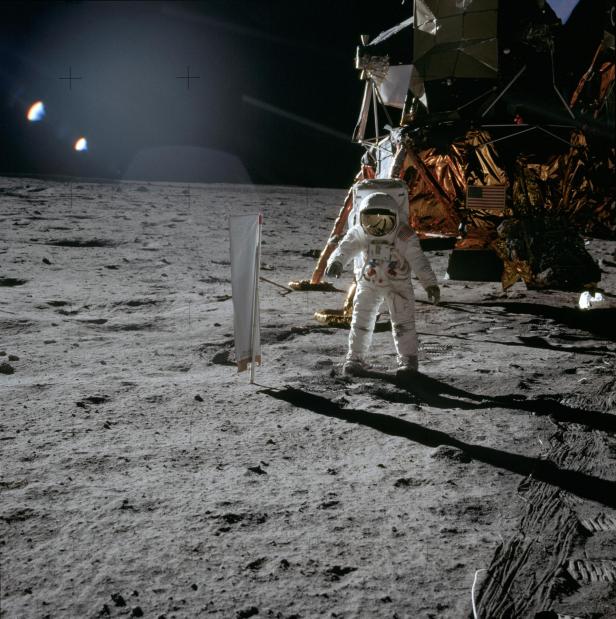 Astronaut Edwin E. Aldrin Jr., lunar module pilot, is photographed during the Apollo 11 extravehicular activity (EVA) on the lunar surface. In the right background is the lunar module. On Aldrin's right is the Solar Wind Composition (SWC) experiment, already deployed. This photograph was taken by astronaut Neil A. Armstrong, commander, with a 70mm lunar surface camera.