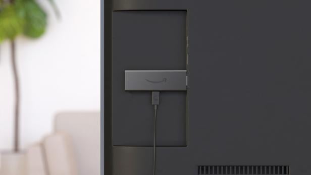 Ein älteres Modell des Fire TV Stick steckt an einem TV-Gerät