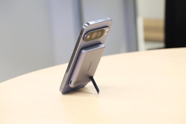 Handy steht mit Standfuß der Powerbank am Tisch