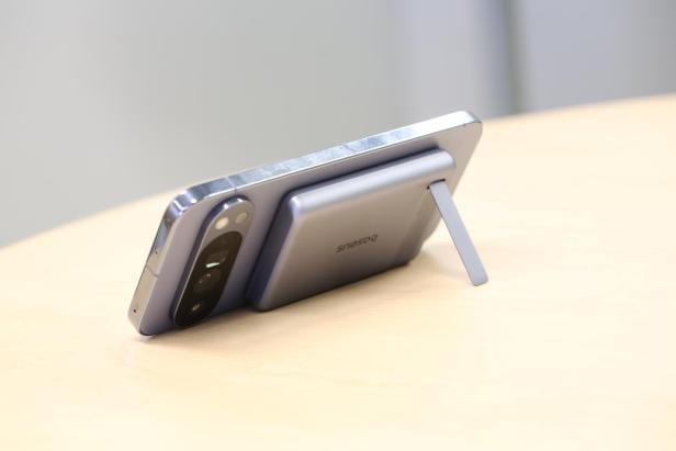 Handy steht mit Standfuß der Powerbank am Tisch