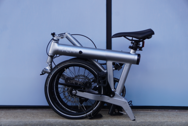 zusammengeklapptes Flit M2 Faltrad vor blauem Hintergrund