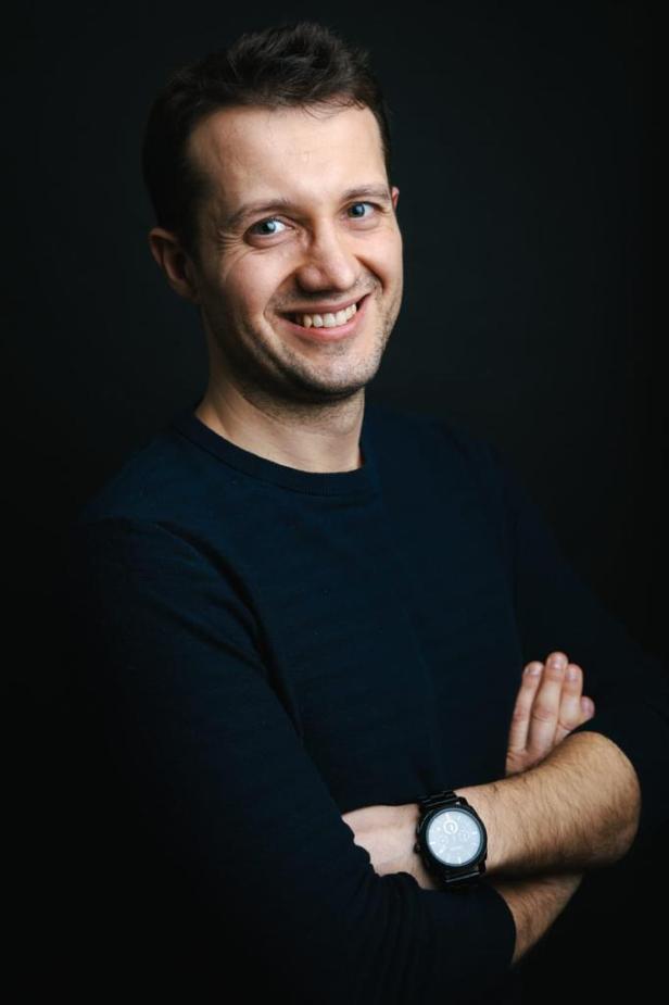 ein Mann mit schwarzem Shirt vor schwarzem Hintergrund