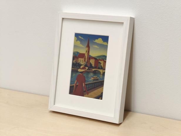 Digitaler Bilderrahmen mit farbigem E-Ink-Display auf einem Holztisch vor einer Wand.