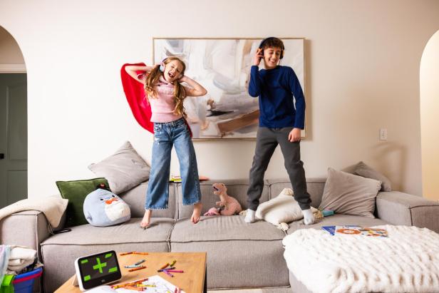 Kinder tanzen mit Kopfhörern auf der Couch