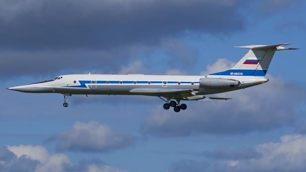 Eine Maschine des Typs Tu-134UB-L fliegt in der Luft vor bewölktem Himmel