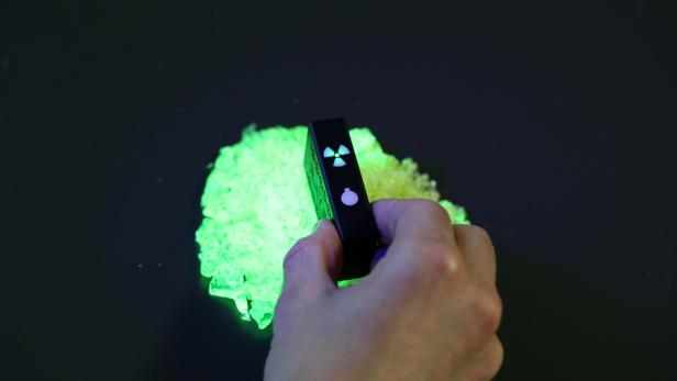 Uranglassplitter, beleuchtet mit einer UV-Taschenlampe
