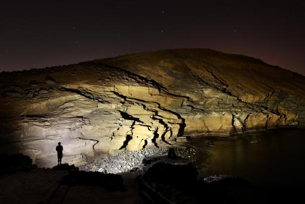 Jemand leuchtet eine Höhle mit einer Duracell Taschenlampe aus