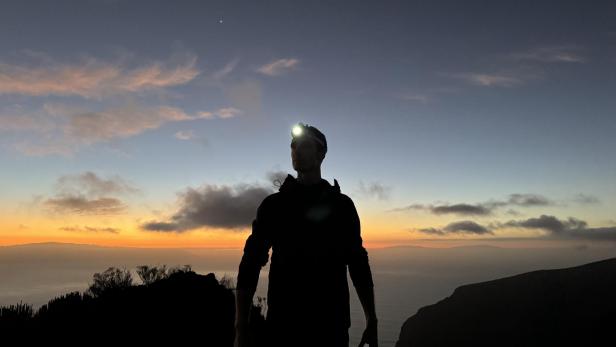 Mann mit Stirnlampe von Duracell in der Dämmerung