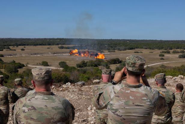 US-Soldaten beobachten bei einer Vorführung auf dem Testgelände in Fort Hood eine große Explosion auf freiem Feld.