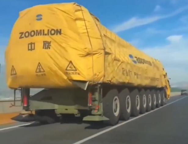 Lkw mit gelber Plane und Zoomlion Aufdruck fährt auf der Straße