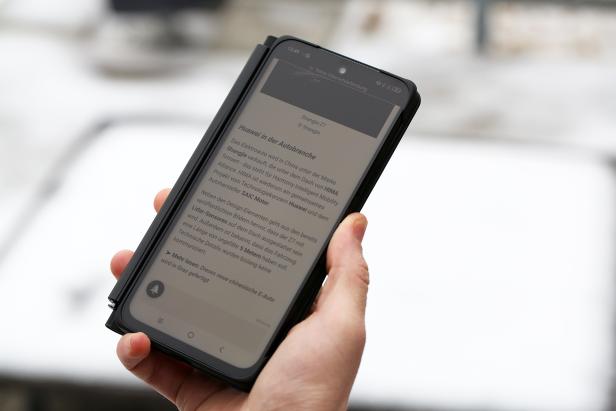 Eine Hand hält das TCL Nxtpaper 60 Ultra mit aktiviertem ePaper-Modus, der das matte Display wie ein E-Ink-Display erscheinen lässt.