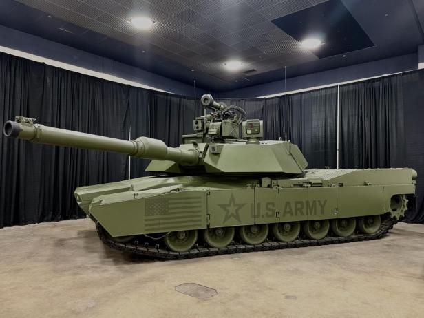 Kampfpanzer M1E3 der US Army mit Raketenwerfer auf dem Turm in einer Messehalle.