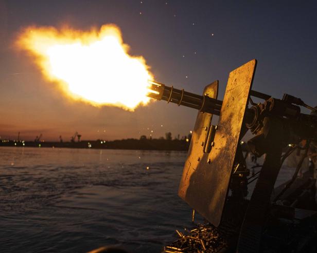 Minigun auf einem Boot wird in der Nacht abgefeuert
