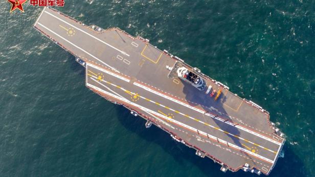 Flugzeugträger auf See aus der Vogelperspektive mit deutlich sichtbarem Flugdeck.
