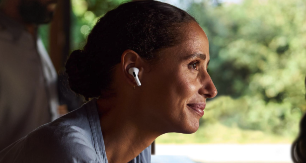 Eine Frau trägt weiße AirPods-Kopfhörer.