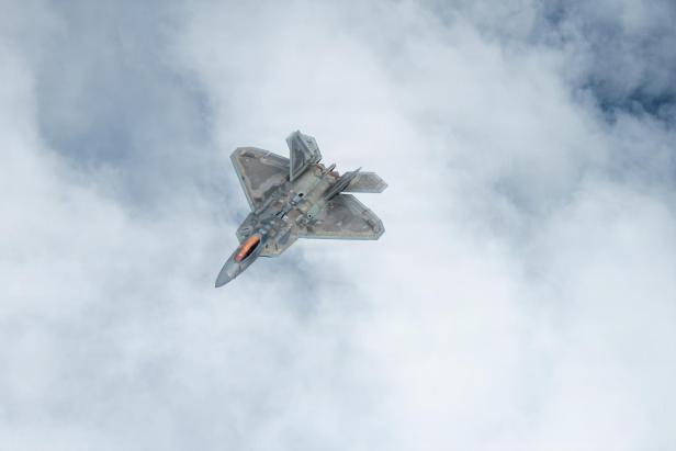 F-22 Stealth-Fighter von oben fotografiert, fliegt über der Wolkendecke