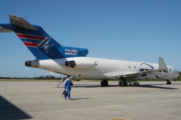 Eine Boeing 727 von Zero-G, bekannt als „G-Force One“, steht auf dem Rollfeld, während eine Person in Overall mit Tasche vorbeigeht.