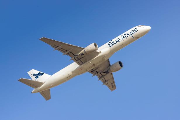 Flugzeug mit der Aufschrift "Blue Abyss" im Flug vor blauem Himmel.