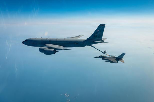 Ein Tankflugzeug betankt ein Kampfflugzeug in der Luft über dem Meer.