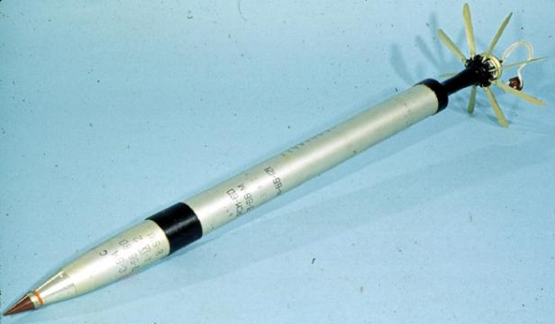 Eine einzelne sowjetische S-5-Rakete mit Stabilisierungsflügeln auf hellem Untergrund.