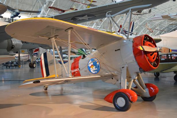 Doppeldecker-Kampfflugzeug Curtiss F9C Sparrowhawk mit roter Motorhaube in einem Flugzeugmuseum.