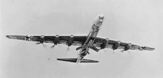 Ein großes Flugzeug mit ausgebreiteten Flügeln trägt ein kleineres Flugzeug unter dem Rumpf.