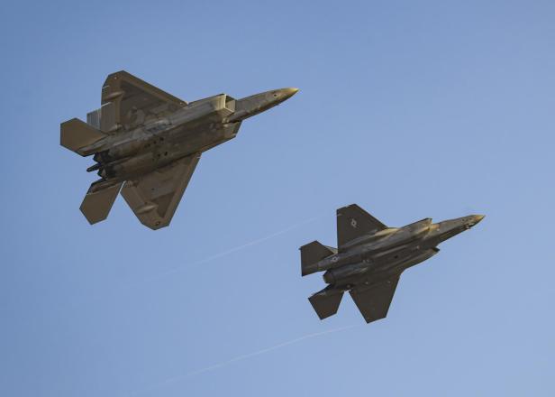 Zwei Tarnkappen-Kampfjets fliegen nebeneinander am Himmel.