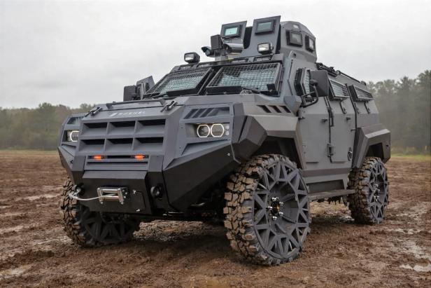 Gepanzertes Militärfahrzeug mit luftlosen, segmentierten Reifen auf schlammigem Untergrund.
