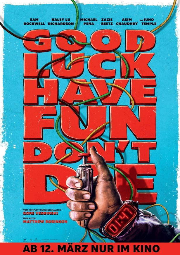 Eine Hand mit digitaler Uhr hält einen Zünder vor großen roten Buchstaben und den Namen der Hauptdarsteller von „Good luck, have fun, don't die“.