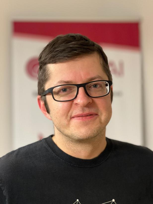 Ein Mann mit Brille und dunklen Haaren