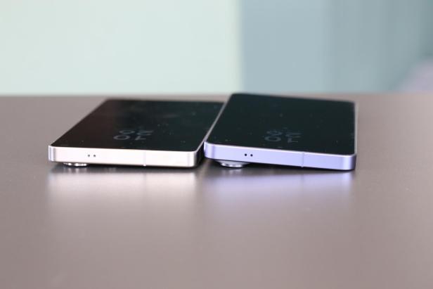 Zwei Smartphones liegen nebeneinander auf einem Tisch, beide mit hervorstehenden Kameramodulen.