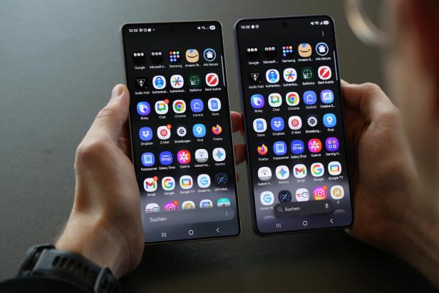Ein Mann hält 2 Smartphones in der Hand. auf beiden werden die App-Icons angezeigt