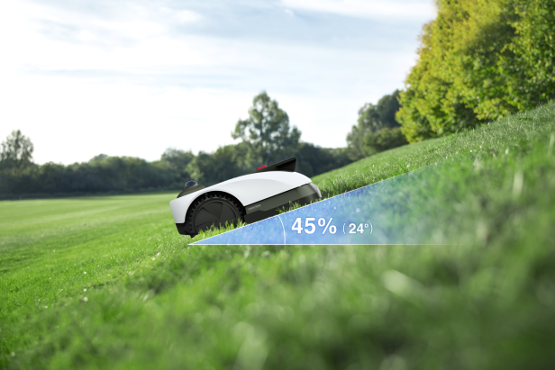Ein Mähroboter fährt eine Wiese mit 45 Grad Steigung hoch 