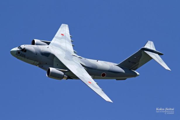 Ein Transportflugzeug aus Japan fliegt vor blauem Himmel