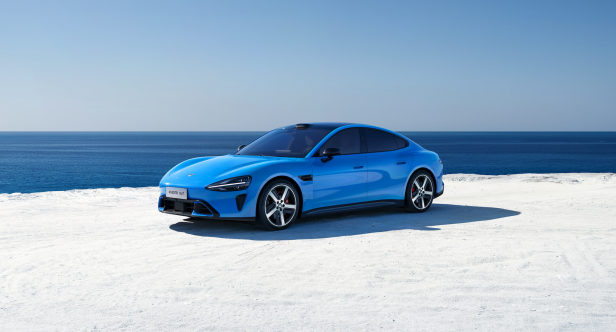 Ein blaues Elektroauto steht auf dem Strand