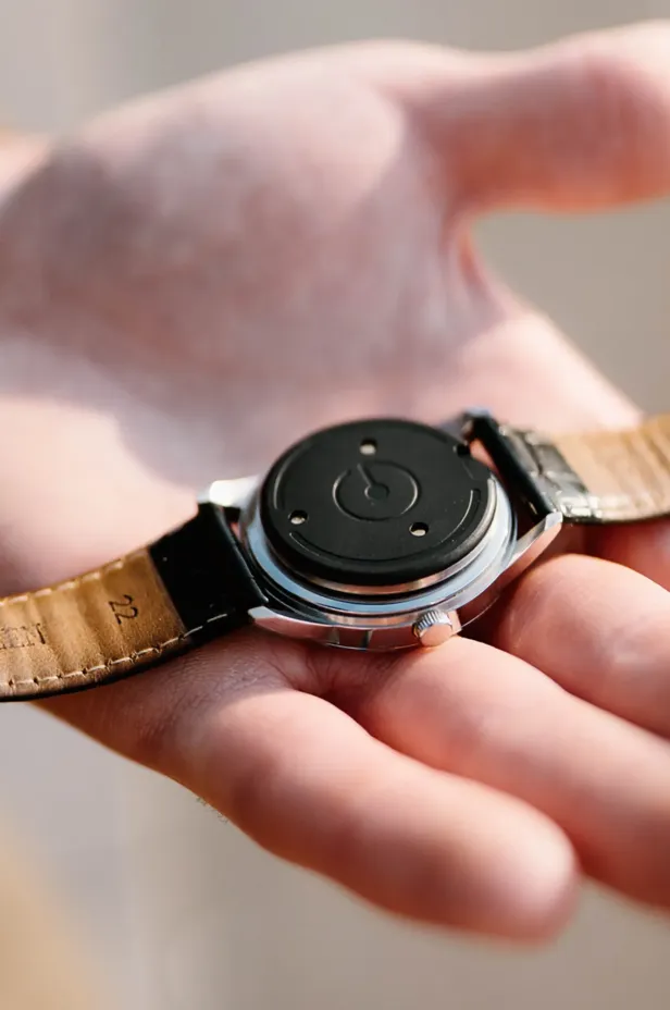 Eine Hand hält eine Uhr, darauf das Ganance-Gerät.