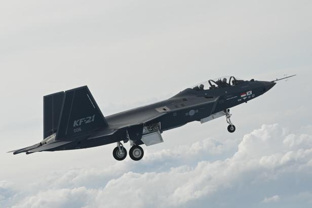 Der südkoreanische Kampfjet KF-21 fliegt mit ausgefahrenem Fahrwerk durch die Wolken.