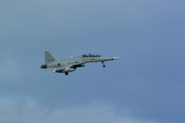 F-5 Kampfjet fliegt vor blauem Himmel