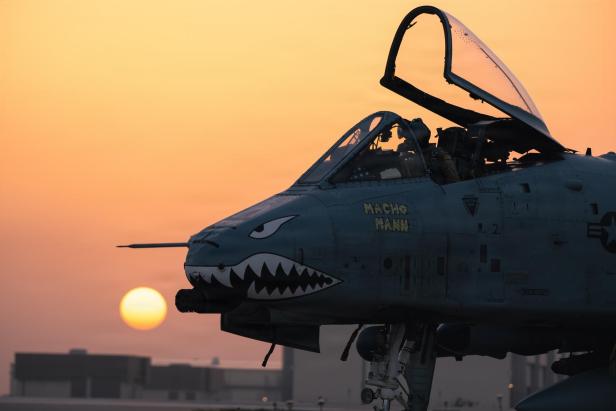 A-10-Kampfflugzeug mit Maul-Bemalung bei Sonnenuntergang auf einem Flugfeld.