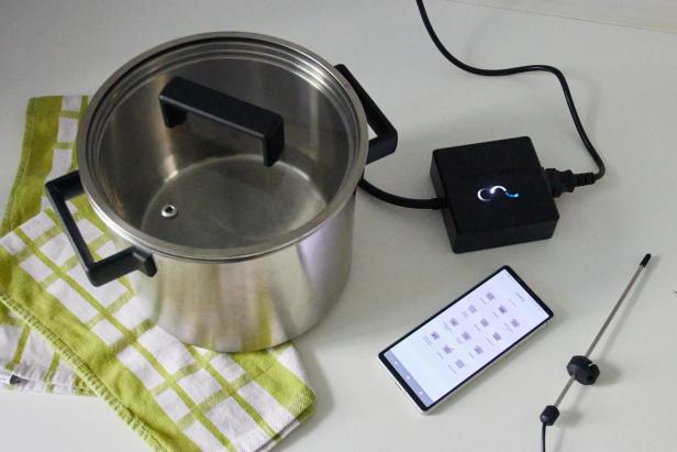Wired Cooker, daneben ein Smartphone mit der Wired Cooking App, in der 12 Geräte zur Auswahl stehen