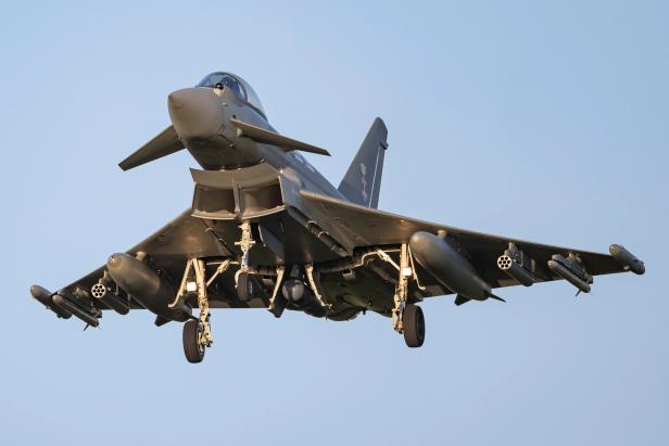 Kampfflugzeug Eurofighter setzt vor blauem Himmel zur Landung an